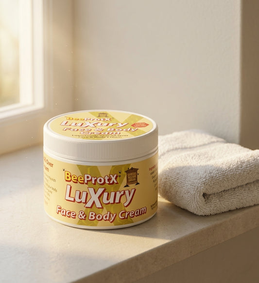 A jar of BeeProtX Luxury Face & Body Cream sits on a beige windowsill next to a folded white towel, with soft natural light shining in from the left.