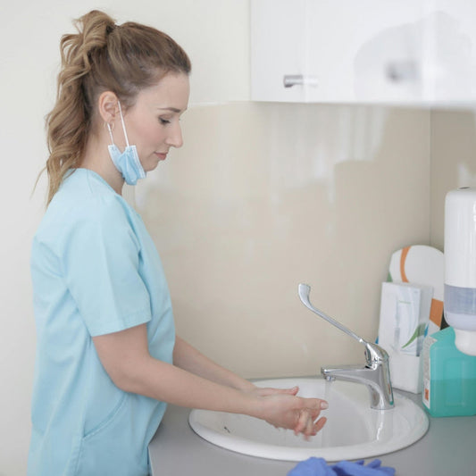 Nurse washing her hands at a sink