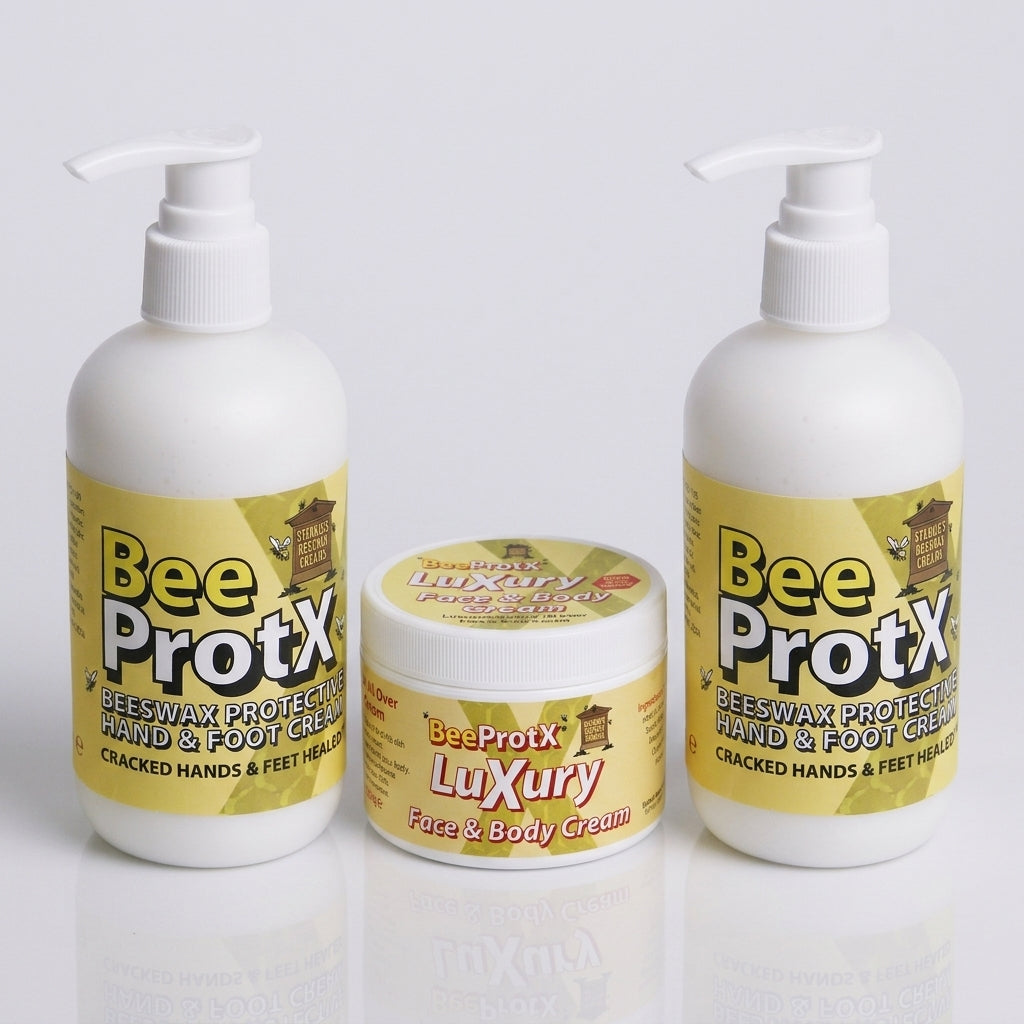Three BeeProtX skincare products on a light gray reflective background: two white pump bottles and one white jar with yellow labels.