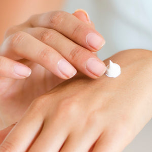 Pair of hands applying hand cream