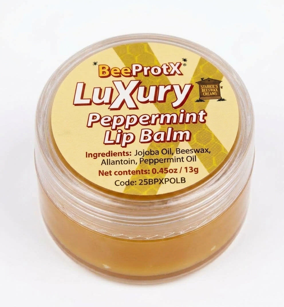 A round clear plastic jar of BeeProtX Luxury Peppermint Lip Balm, showing the golden-brown balm inside, with a yellow label on a white background.